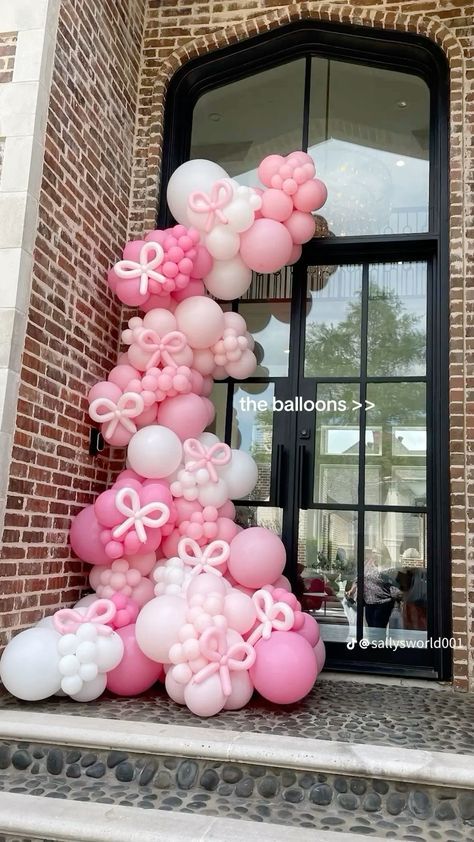 balloons are arranged in the shape of a tree on top of steps outside a building