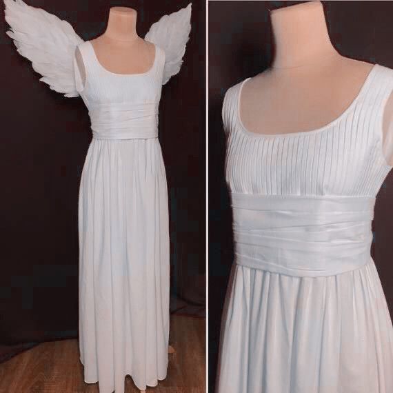 a white dress with angel wings on the shoulders and back, next to a mannequin