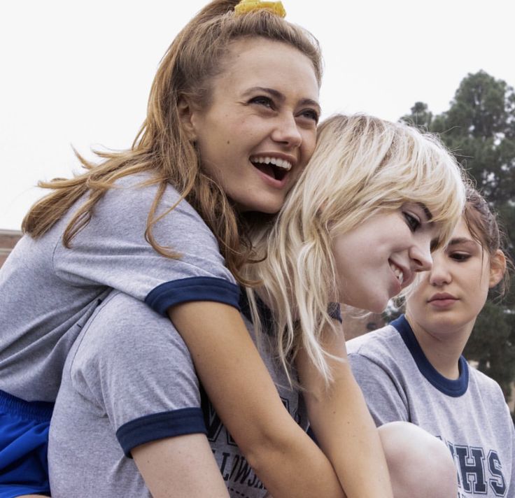 three girls are hugging each other outside