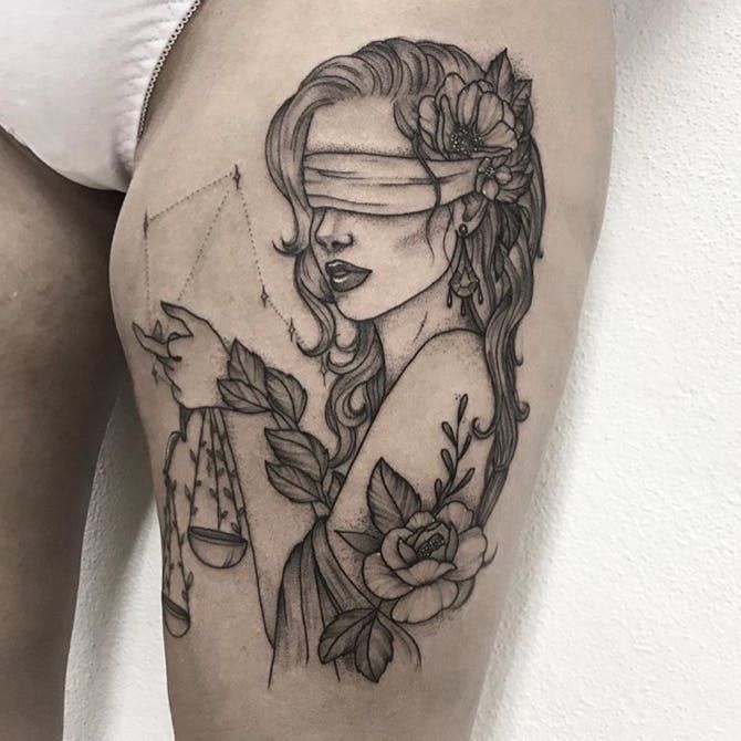 a woman with a blindfolded face and flowers on her thigh