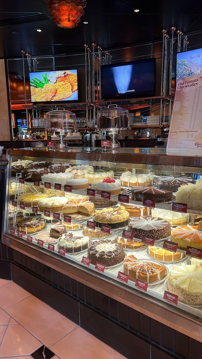 a display case filled with lots of different types of cakes and pies on top of it