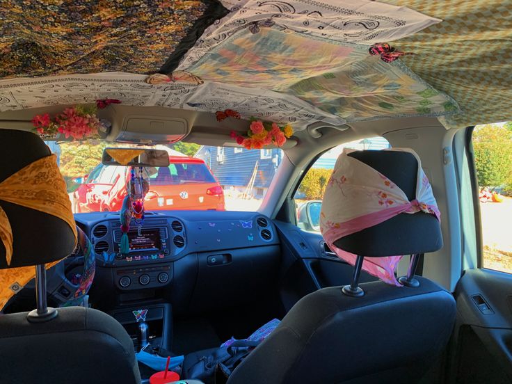 two people sitting in the back seat of a car with umbrellas hanging from the ceiling