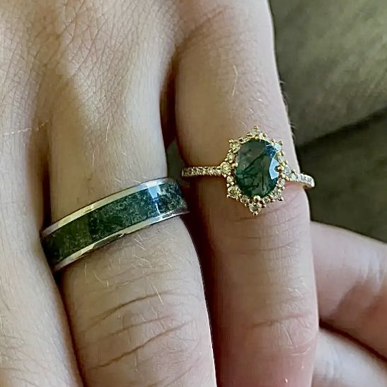 a woman's hand with a ring on it and a green stone in the middle