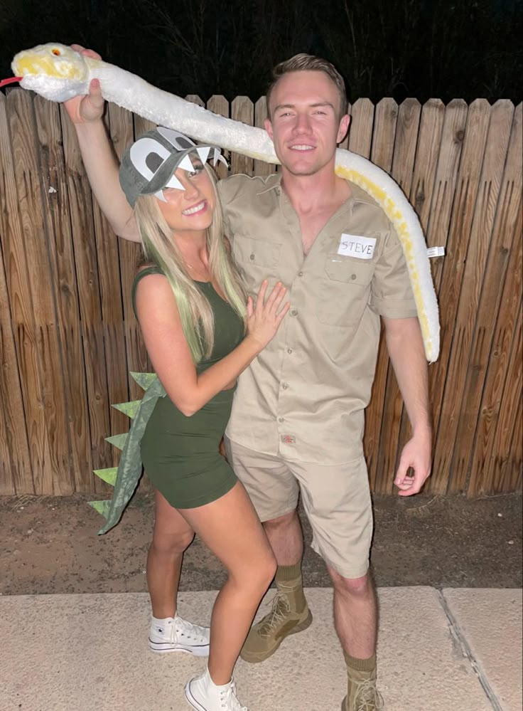 a man and woman are dressed up as they pose for a photo with a fake snake on their head