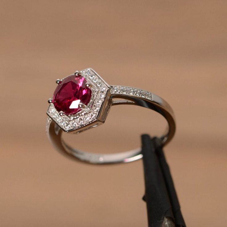 It is a lab ruby ring. The main stone is 7mm round cut, weight about 1.65 carats. The basic metal is sterling silver and plated with rhodium. To change the metal to a solid gold (white/rose) or platinum is also available, please ask for a quotation if you want. You can also go to my shop Home for more elegant rings: https://www.etsy.com/shop/godjewelry?ref=hdr_shop_menu Ruby is the birthstone of July, it will be a great gift for your lover! More ruby rings: https://www.etsy.com/shop/godjewelry?r Lab-created Ruby Ring With Halo Design, Lab-created Ruby Birthstone Ring With Halo Setting, Octagon Ruby Ring In Fine Jewelry Style, Octagon Ruby Ring Fine Jewelry, Lab-created Ruby Ring With Halo Setting, Classic Silver Halo Ring With Ruby, Classic Ruby Octagon Ring, Classic Silver Ruby Ring With Halo Design, Classic Ruby Ring With Halo Setting In Sterling Silver