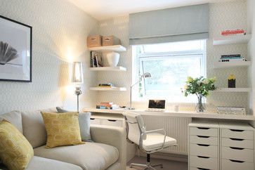 a living room with a couch, desk and shelves on the wall next to it