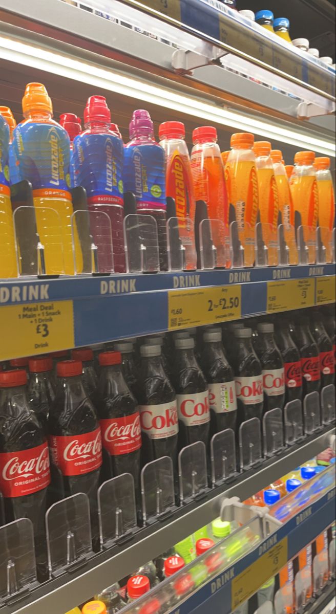 many different types of sodas are on display in a grocery store, and one is empty