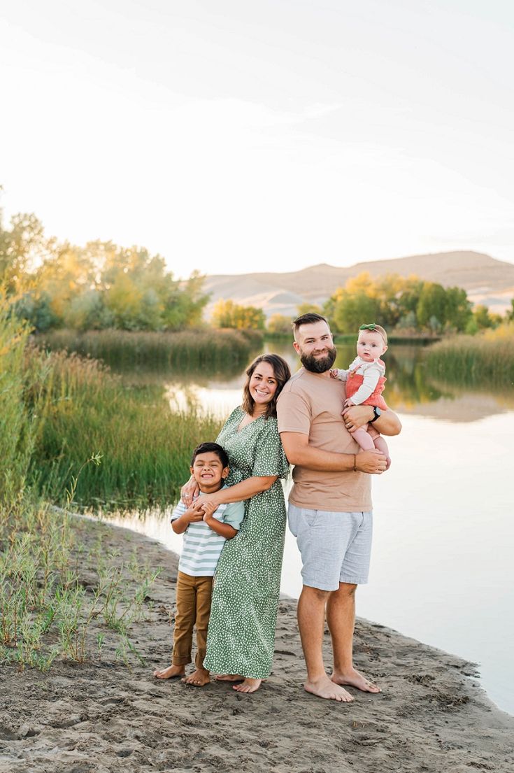 a family poses for a photo by the water