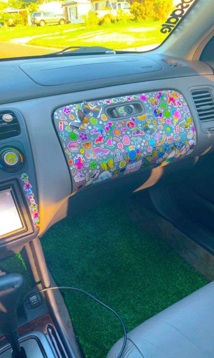 the interior of a car with colorful flowers on the dash board and steering wheel cover