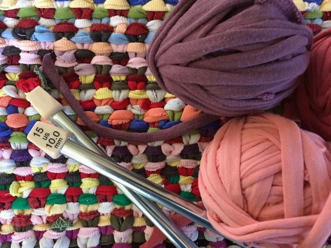 crochet needles and balls of yarn on a rug