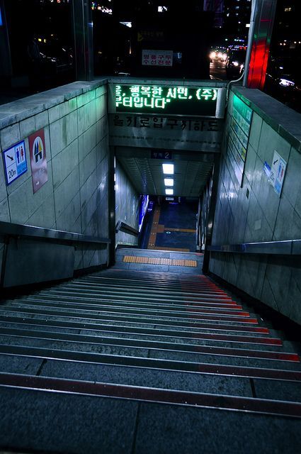 an escalator with stairs leading up to it at night