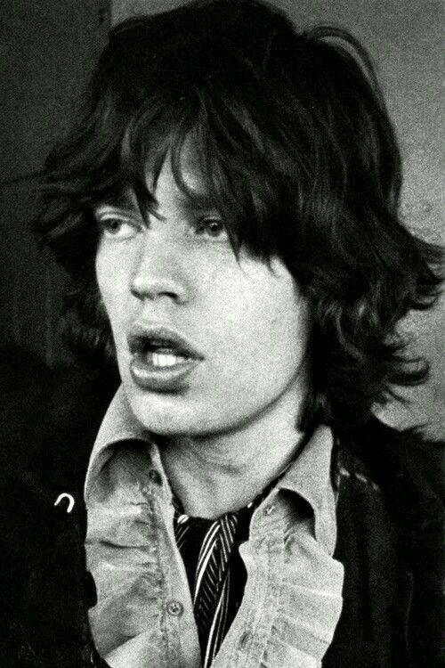 black and white photograph of a young man with long hair wearing a shirt and tie