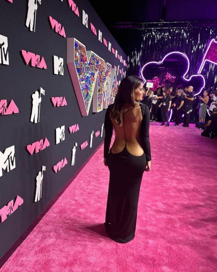 a woman standing in front of a pink carpet