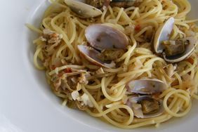 pasta with clams and sauce in a white bowl