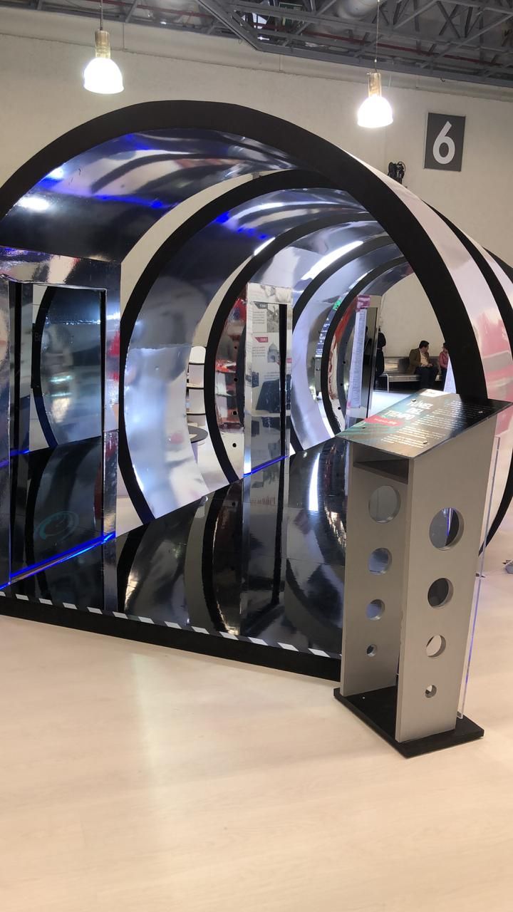 a large display case in the middle of a room with several circular mirrors on it