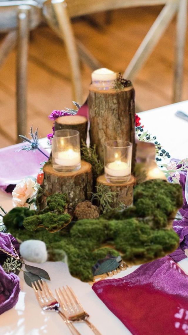 the table is set with candles and moss