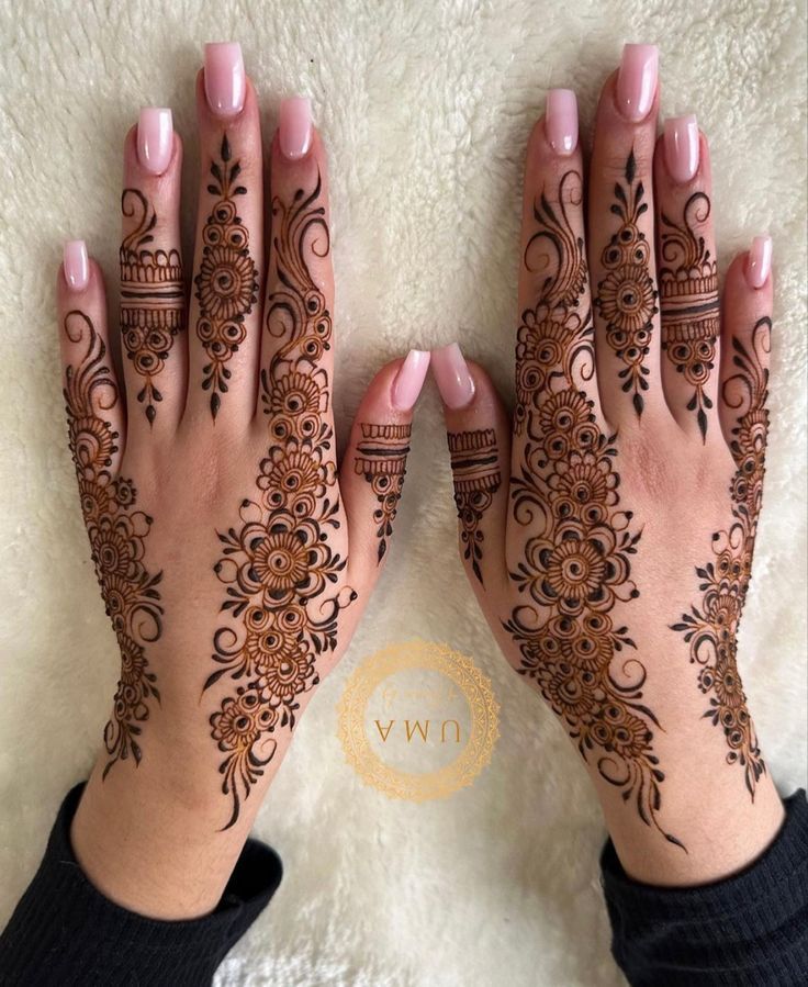 two hands with henna tattoos on them