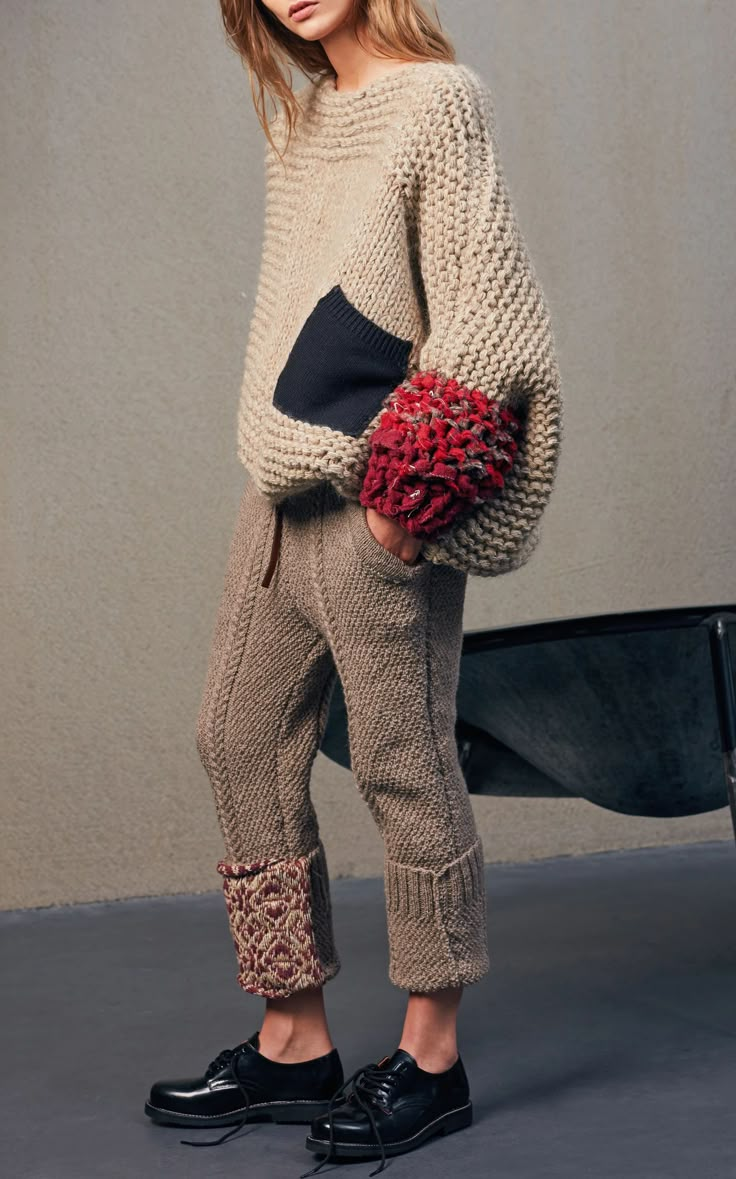 a woman standing next to a wheelbarrow holding a bouquet of flowers in her hand