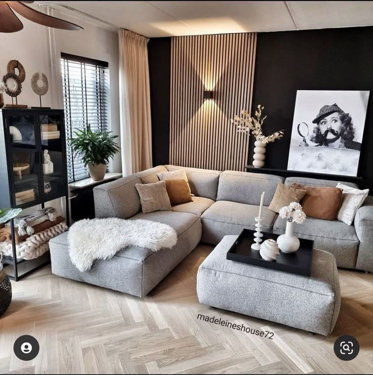 a living room filled with lots of furniture next to a wall mounted painting on the wall