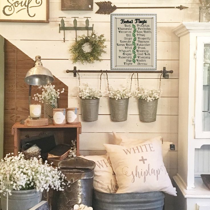 a living room filled with lots of furniture and flowers in buckets on the wall