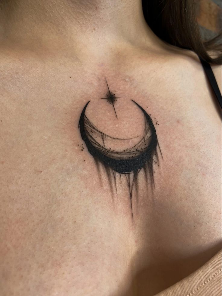 a woman's chest with a crescent tattoo on it