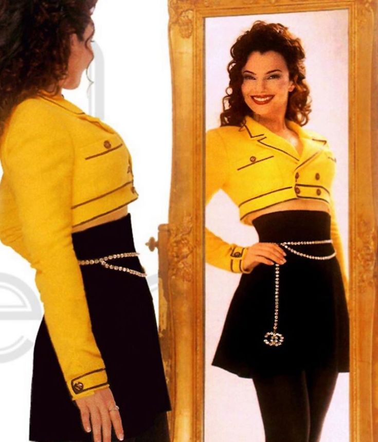 a woman is looking at herself in the mirror with her hand on her hip belt