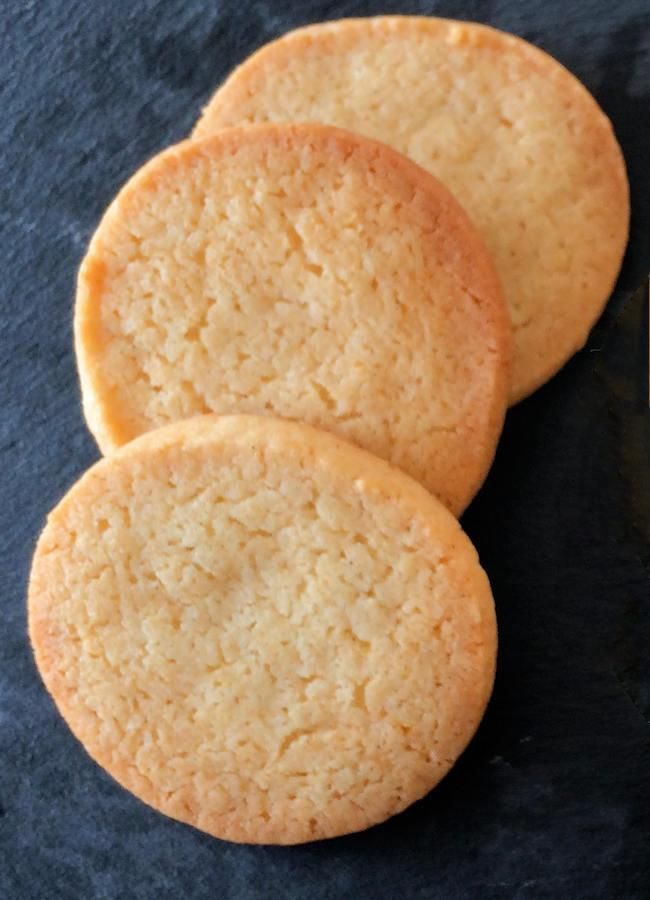 three cookies sitting next to each other on top of a black surface with one cookie in the middle