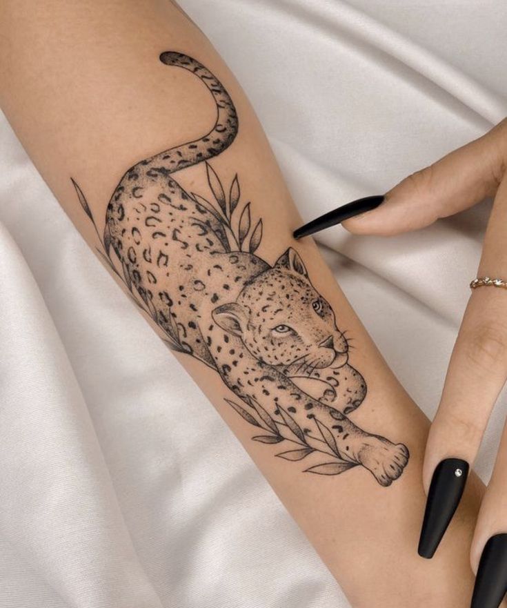 a woman's arm with a tattoo of a leopard on it