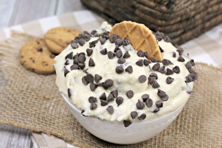 a bowl filled with ice cream topped with chocolate chips and a cracker on top