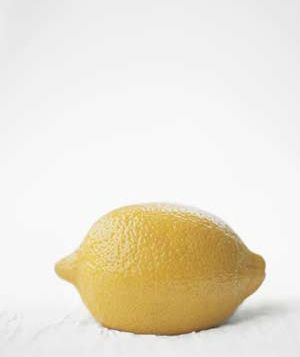 a lemon sitting on top of a white table