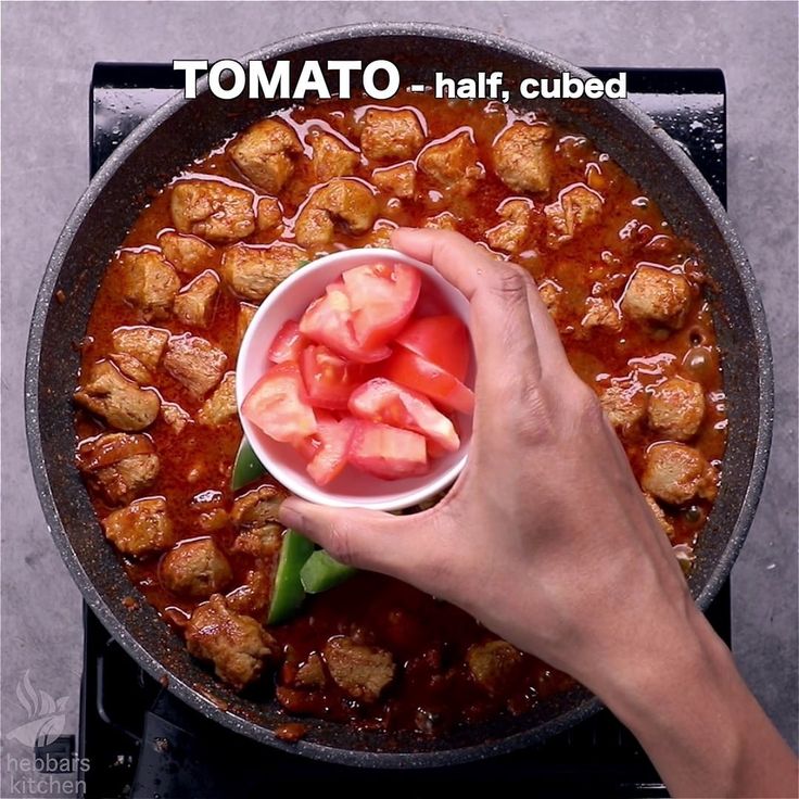 a person holding a bowl with food in it on top of a stove burner