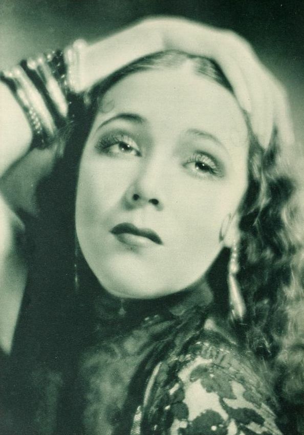 an old black and white photo of a woman with curly hair wearing a headband