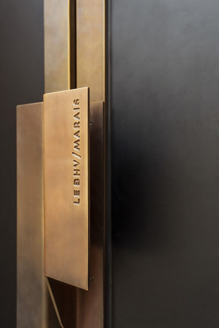 a close up of a metal door handle on a black and gold door with the name savannah written on it