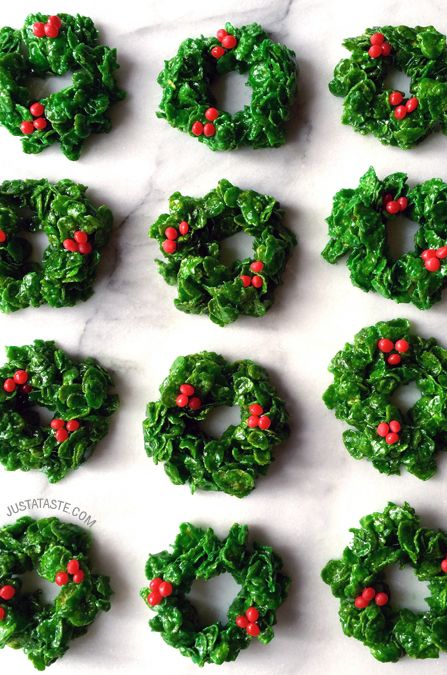 christmas wreaths made out of spinach and red berries are arranged on a marble surface