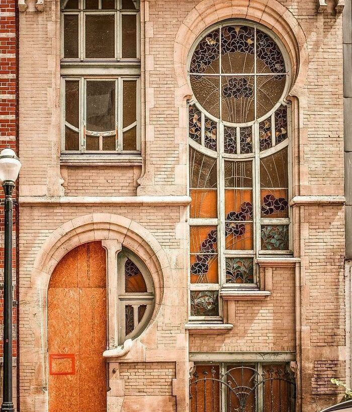 an old brick building with a wooden door and arched windows on the side of it