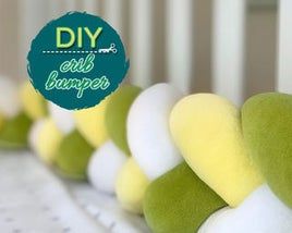 a row of green and white balls sitting on top of a bed