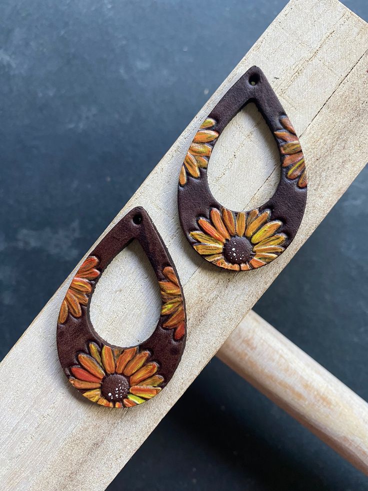 pair of wooden earrings with painted flowers on them