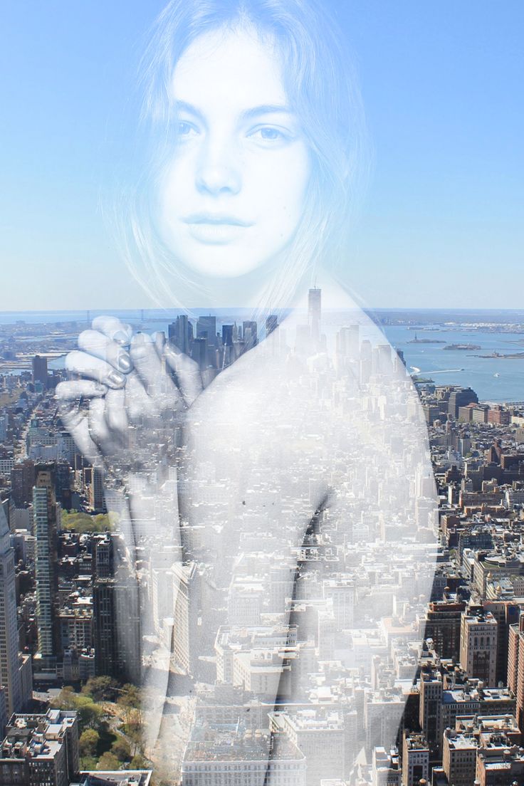 a woman standing in front of a large city