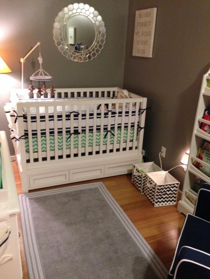 a baby's room with gray walls and white crib