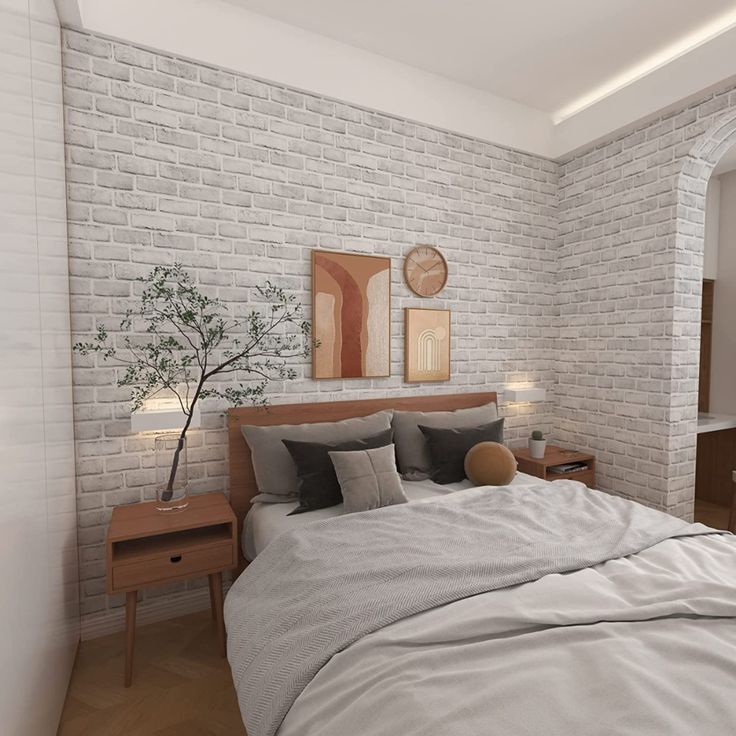 a bedroom with white brick walls and grey bedding