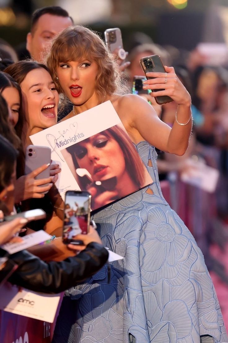 taylor swift signs autographs for fans on the red carpet