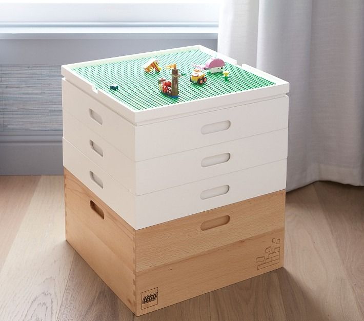 a stack of boxes sitting on top of a hard wood floor next to a window