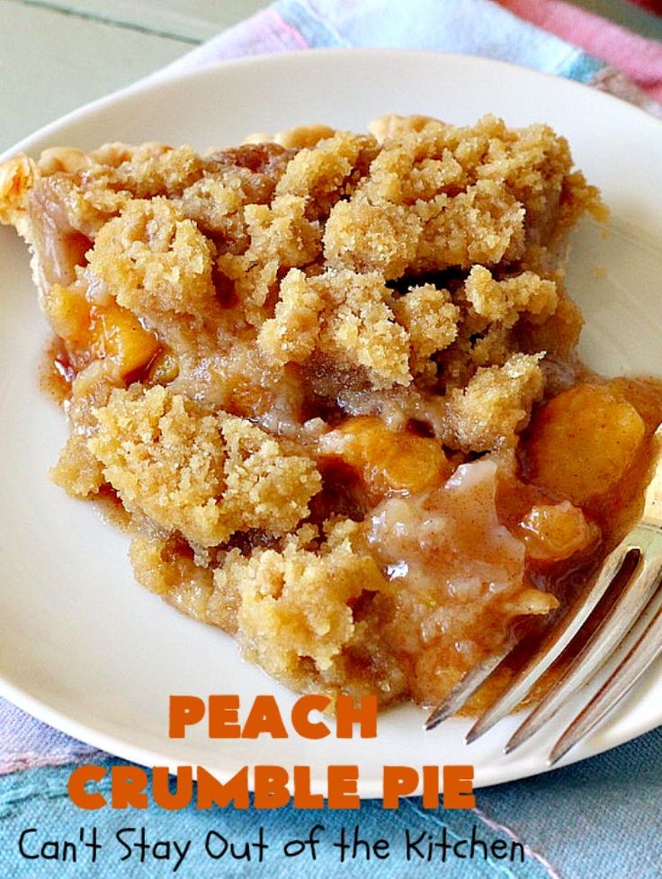 a piece of peach crumble pie on a white plate with a fork next to it