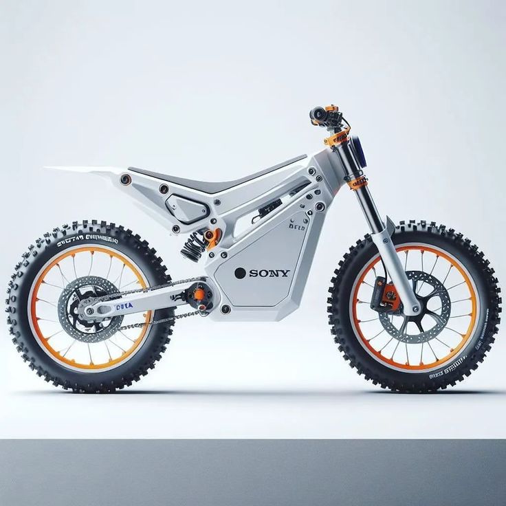 a white and orange dirt bike parked on top of a gray floor next to a wall