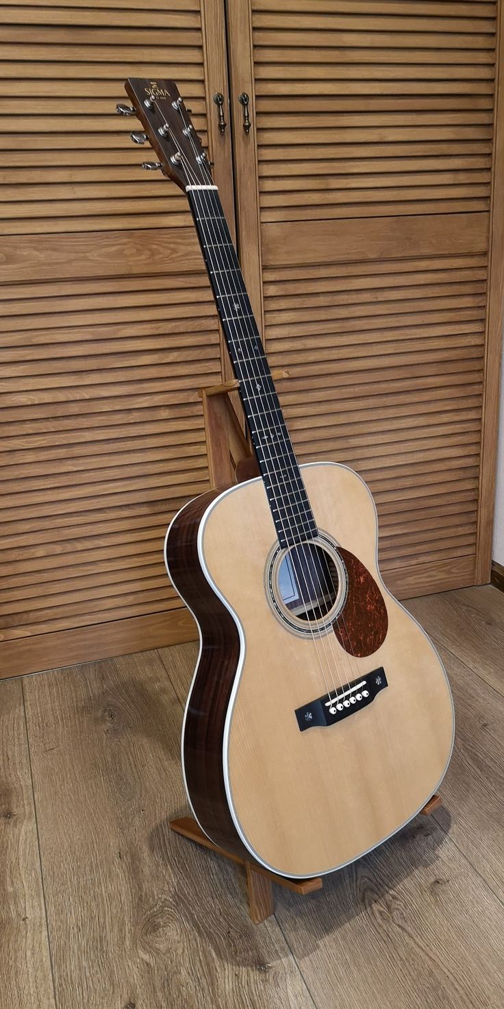 an acoustic guitar sitting on top of a wooden floor