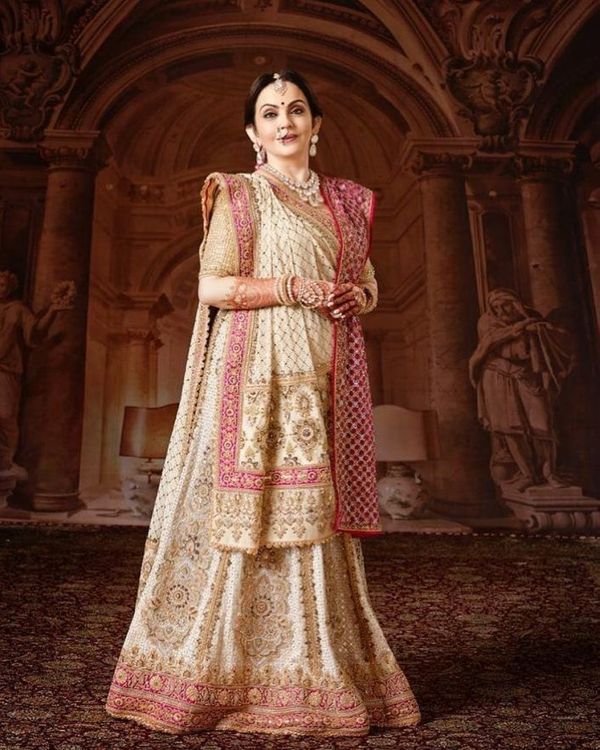 a woman in a white and pink lehenga