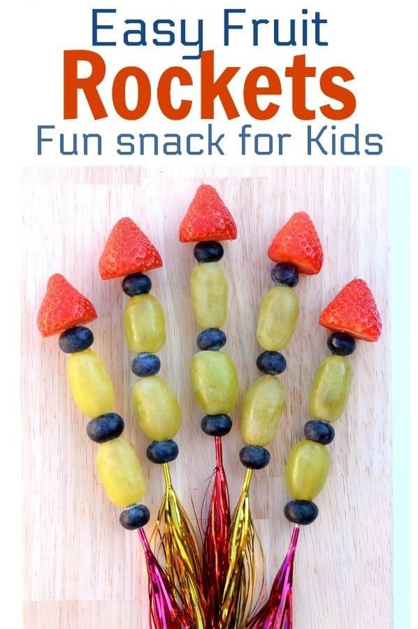 an easy fruit rocket made out of bananas, strawberries and blueberries with text overlay that reads easy fruit rockets fun snack for kids