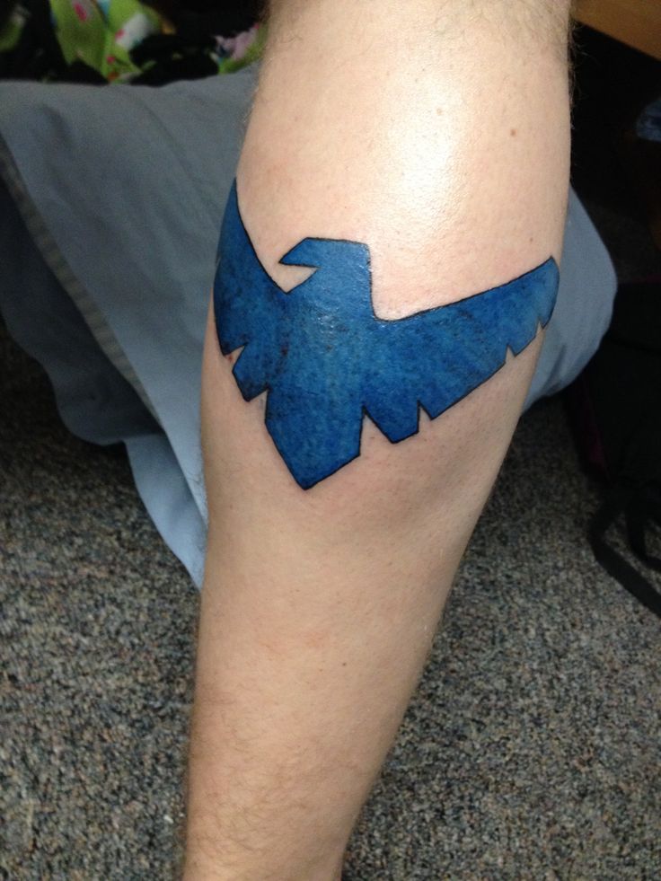 a man's leg with a blue bird tattoo on it