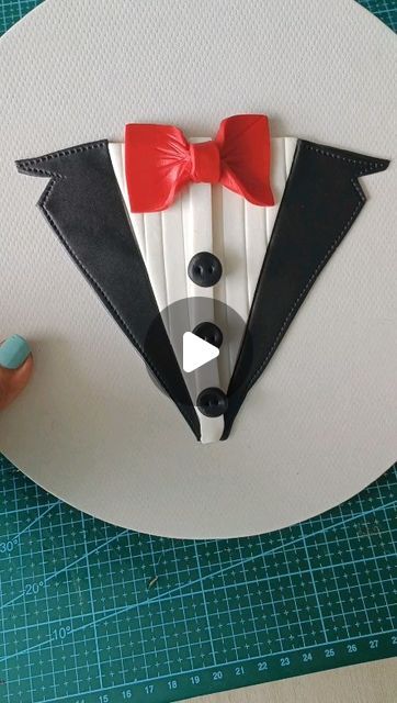 a paper cut out of a man's tuxedo wearing a red bow tie