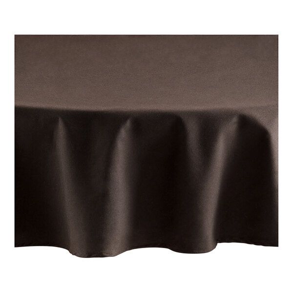 a black table cloth on top of a white table with a brown cover over it